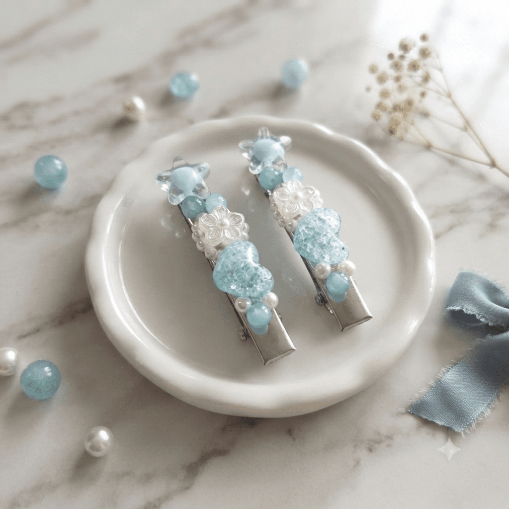 Two aqua blue and pearl-look beaded hair clips displayed on a white ceramic dish