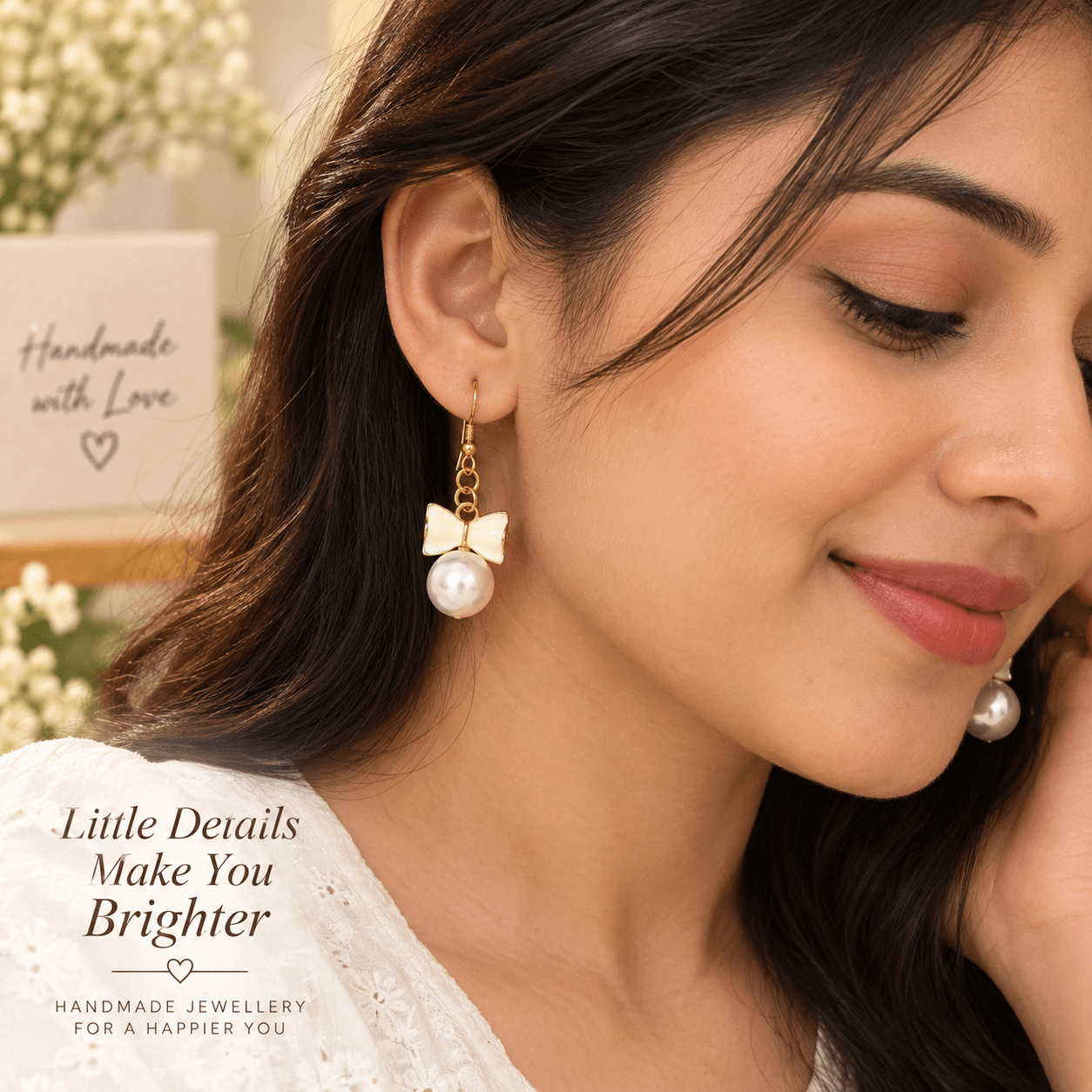 Woman wearing white bow and pearl-look dangle earrings with gold-tone details